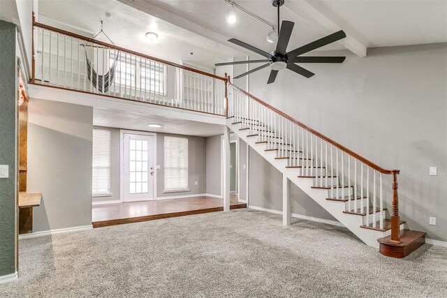 816 Woodbury Dr, Edmond, OK 73034 - unfurnished living room featuring carpet flooring, stairway, a ceiling fan, a towering ceiling, and beam ceiling