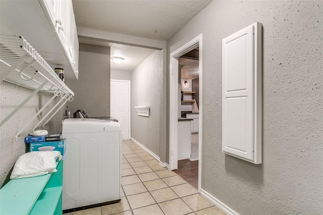 816 Woodbury Dr, Edmond, OK 73034 - washroom with washer / dryer, light tile patterned floors, cabinet space, a textured wall, and a textured ceiling