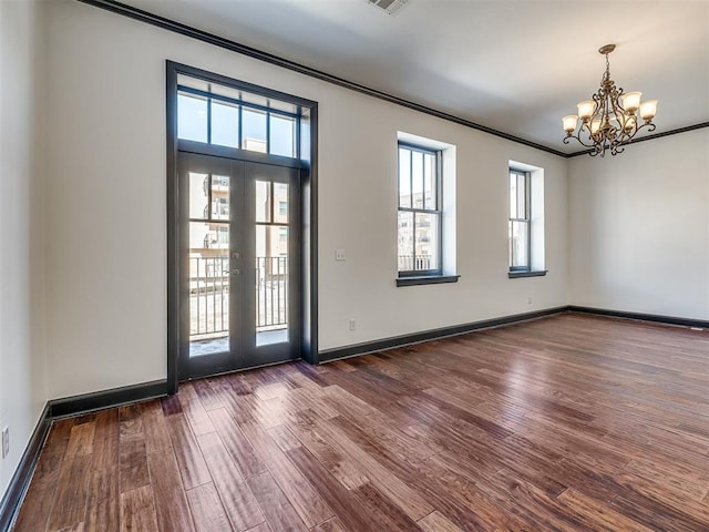 23 NE 3rd St, Oklahoma City, OK 73104 - unfurnished room featuring a chandelier, dark wood-style floors, ornamental molding, and baseboards