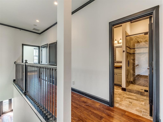 23 NE 3rd St, Oklahoma City, OK 73104 - hall featuring wood finished floors, crown molding, baseboards, recessed lighting, and an upstairs landing