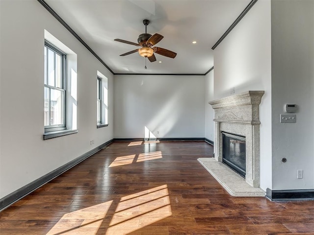 23 NE 3rd St, Oklahoma City, OK 73104 - unfurnished living room featuring ceiling fan, a glass covered fireplace, ornamental molding, wood finished floors, and baseboards