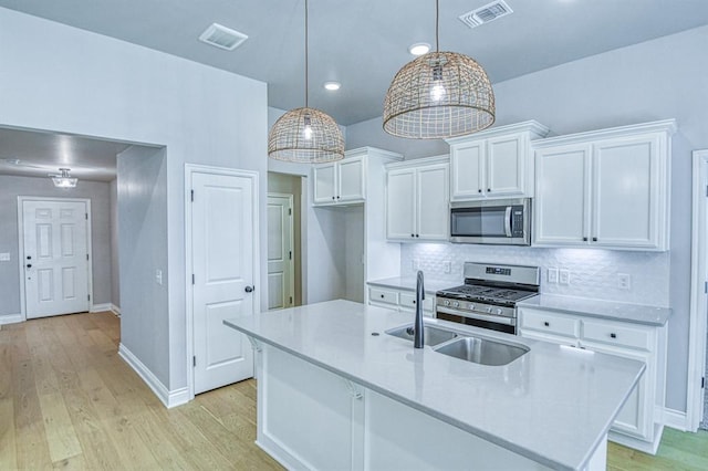 3232 Pagoda Pead Dr, Yukon, OK 73099 - kitchen featuring stainless steel appliances, white cabinetry, light wood finished floors, light countertops, and recessed lighting