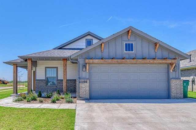 11100 NW 131st St, Yukon, OK 73099 - view of front of house featuring board and batten siding, concrete driveway, brick siding, a garage, and roof with shingles