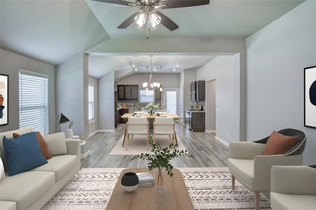 11100 NW 131st St, Yukon, OK 73099 - living room featuring a chandelier, baseboards, lofted ceiling, ceiling fan, and light wood-style floors