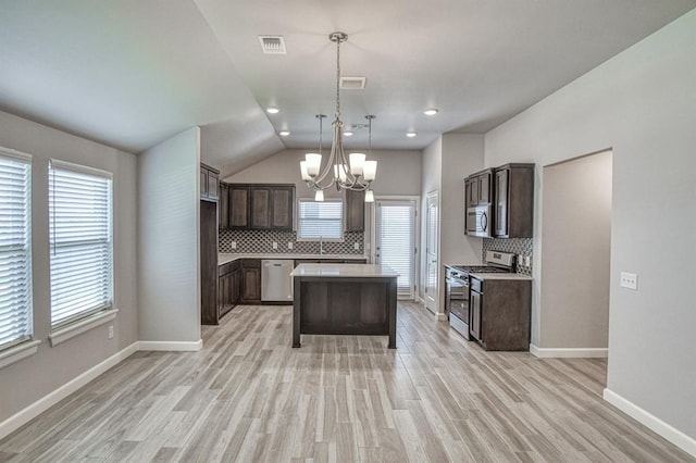 11100 NW 131st St, Yukon, OK 73099 - kitchen with appliances with stainless steel finishes, a chandelier, dark brown cabinets, backsplash, and lofted ceiling