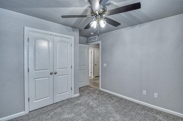 11100 NW 131st St, Yukon, OK 73099 - unfurnished bedroom with carpet flooring, baseboards, a closet, and a ceiling fan