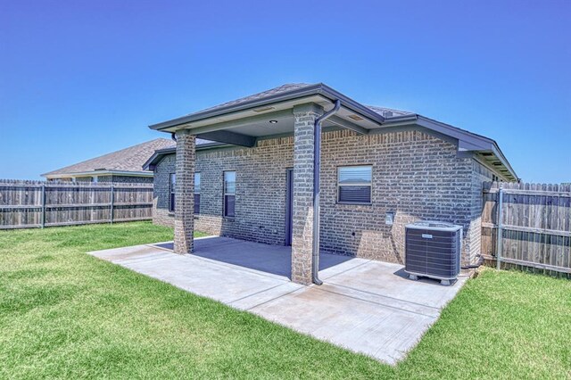 11100 NW 131st St, Yukon, OK 73099 - back of house with central air condition unit, a patio area, and brick siding