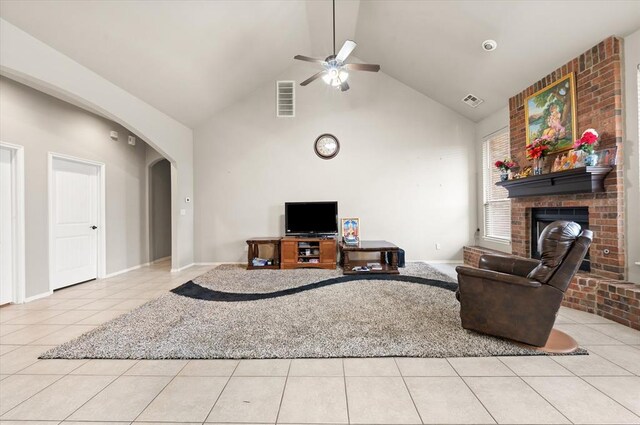 3401 First Capitol Cir, Guthrie, OK 73044 - living room featuring arched walkways, light tile patterned floors, a ceiling fan, a fireplace, and high vaulted ceiling