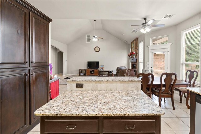 3401 First Capitol Cir, Guthrie, OK 73044 - kitchen with ceiling fan, a kitchen island, light tile patterned flooring, a fireplace, and open floor plan