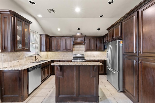 3401 First Capitol Cir, Guthrie, OK 73044 - kitchen with appliances with stainless steel finishes, a sink, light tile patterned floors, a kitchen island, and vaulted ceiling