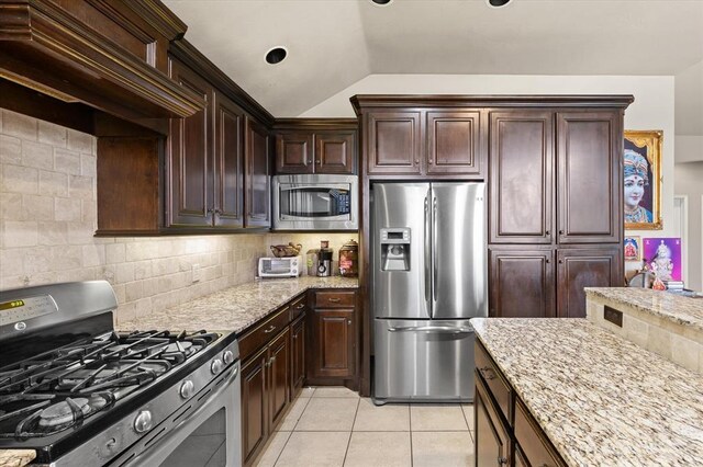 3401 First Capitol Cir, Guthrie, OK 73044 - kitchen with appliances with stainless steel finishes, vaulted ceiling, tasteful backsplash, light stone counters, and light tile patterned flooring