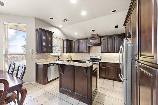 3401 First Capitol Cir, Guthrie, OK 73044 - kitchen featuring stainless steel appliances, tasteful backsplash, dark brown cabinets, light tile patterned floors, and vaulted ceiling