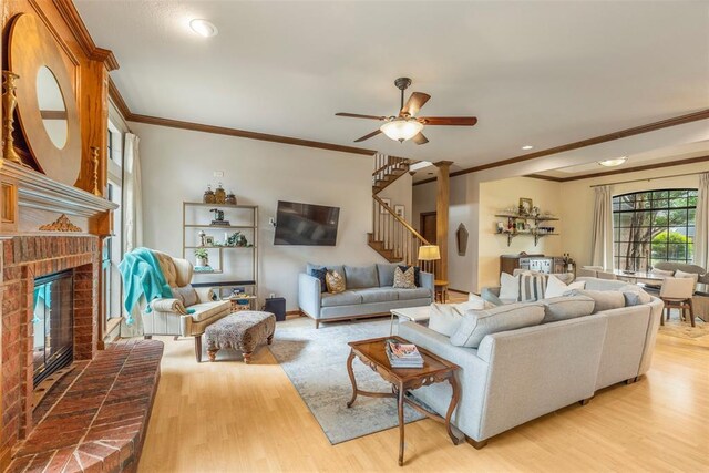 4001 Innsbrook Ct, Norman, OK 73072 - living room featuring stairway, crown molding, light wood-type flooring, a fireplace, and ceiling fan