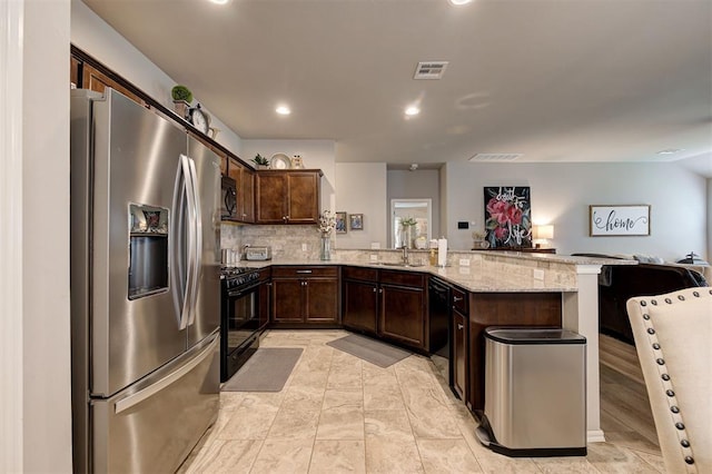 11513 SW 26th St, Yukon, OK 73099 - kitchen featuring black appliances, open floor plan, a peninsula, dark brown cabinets, and recessed lighting