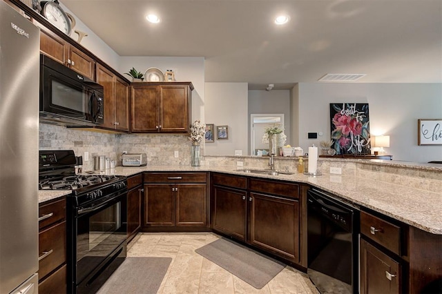 11513 SW 26th St, Yukon, OK 73099 - kitchen featuring black appliances, a sink, decorative backsplash, light stone countertops, and dark brown cabinets