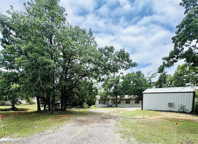 4300 S Rabbit Run, Edmond, OK 73034 - view of green lawn with a pole building, gravel driveway, and an outdoor structure