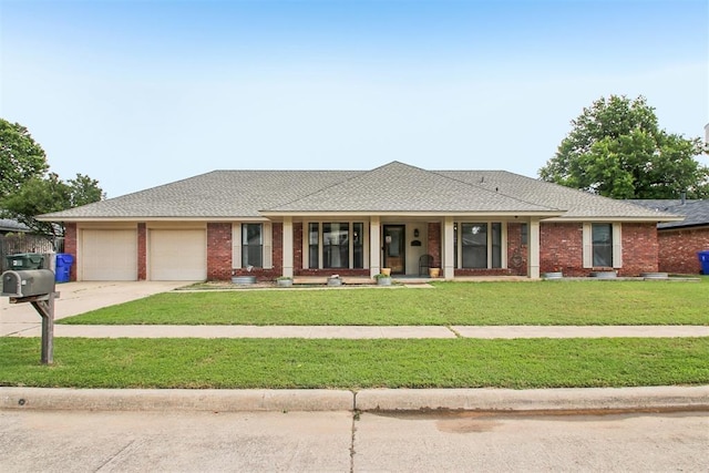 4211 Blue Sage Rd, Norman, OK 73072 - ranch-style home with an attached garage, covered porch, a front lawn, brick siding, and concrete driveway