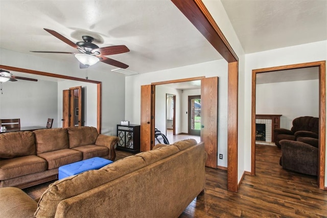 4211 Blue Sage Rd, Norman, OK 73072 - living area featuring a ceiling fan, dark wood-type flooring, a brick fireplace, and baseboards