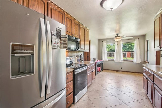 4211 Blue Sage Rd, Norman, OK 73072 - kitchen featuring appliances with stainless steel finishes, ceiling fan, tasteful backsplash, light tile patterned floors, and light countertops