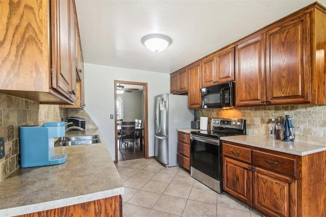 4211 Blue Sage Rd, Norman, OK 73072 - kitchen featuring stainless steel appliances, a sink, backsplash, and light tile patterned flooring