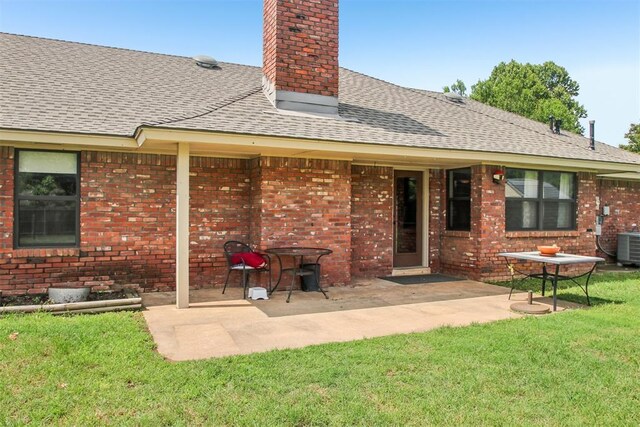 4211 Blue Sage Rd, Norman, OK 73072 - rear view of house featuring a chimney, roof with shingles, a lawn, a patio area, and brick siding