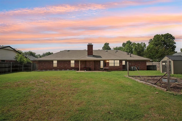 4211 Blue Sage Rd, Norman, OK 73072 - back of house at dusk with a patio, brick siding, and a chimney