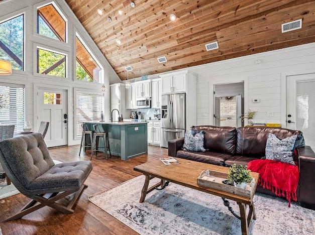 284 Red Berry Trl, Broken Bow, OK 74728 - living room featuring high vaulted ceiling, healthy amount of natural light, wooden ceiling, wood finished floors, and wood walls