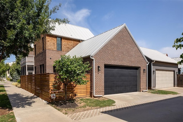 1801 Runway Blvd, Oklahoma City, OK 73108 - view of front of property featuring brick siding, a garage, concrete driveway, and a metal roof
