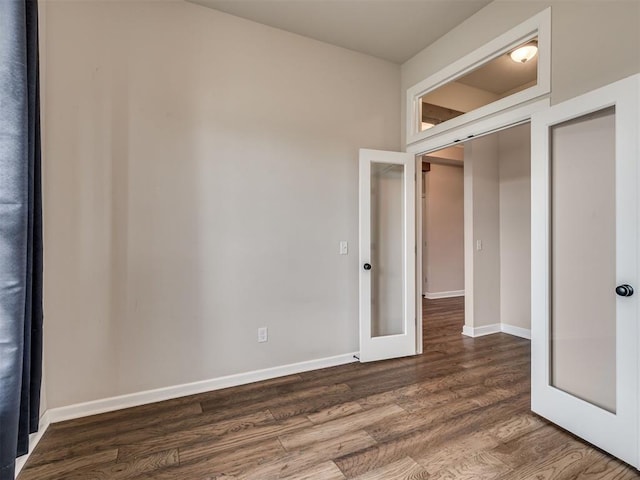 915 Kings Canyon Rd, Norman, OK 73071 - unfurnished bedroom featuring wood finished floors, french doors, and baseboards