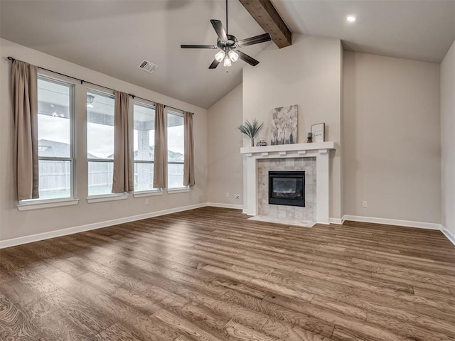 915 Kings Canyon Rd, Norman, OK 73071 - unfurnished living room featuring dark wood-style flooring, beam ceiling, a ceiling fan, baseboards, and a tile fireplace