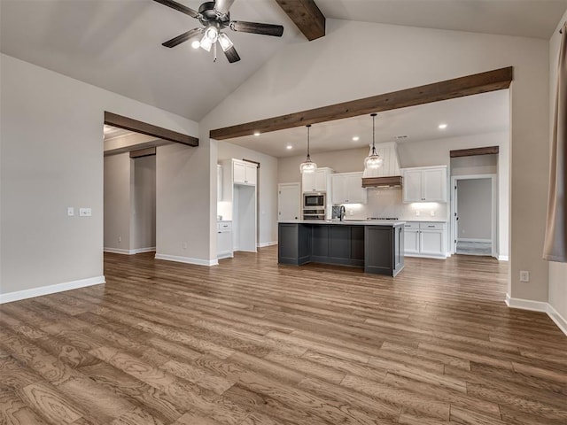 915 Kings Canyon Rd, Norman, OK 73071 - kitchen with beamed ceiling, recessed lighting, white cabinetry, ceiling fan, and dark wood finished floors