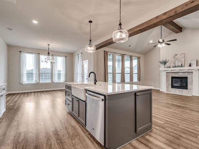 915 Kings Canyon Rd, Norman, OK 73071 - kitchen featuring dishwasher, gray cabinetry, a sink, a tiled fireplace, and light wood-style flooring