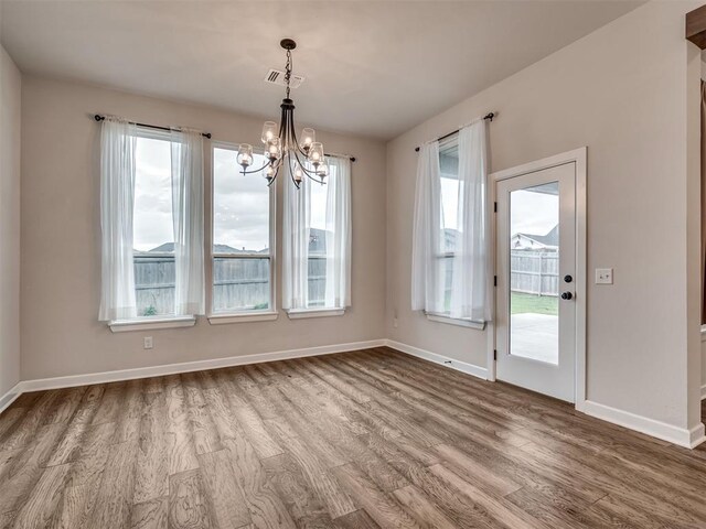 915 Kings Canyon Rd, Norman, OK 73071 - unfurnished dining area featuring wood finished floors, a chandelier, and baseboards