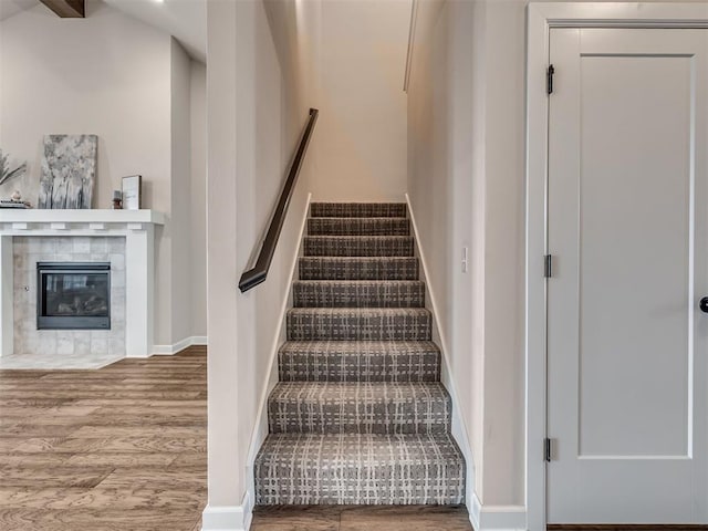915 Kings Canyon Rd, Norman, OK 73071 - staircase featuring wood finished floors, a fireplace, and baseboards
