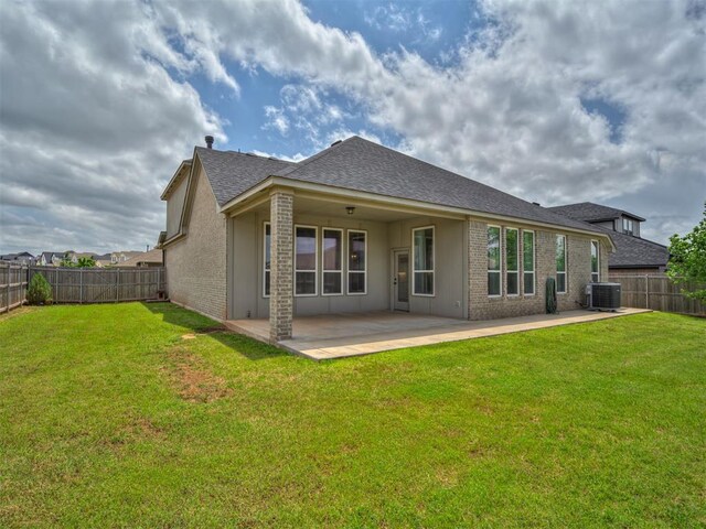 915 Kings Canyon Rd, Norman, OK 73071 - rear view of house with cooling unit, a patio area, a shingled roof, and brick siding
