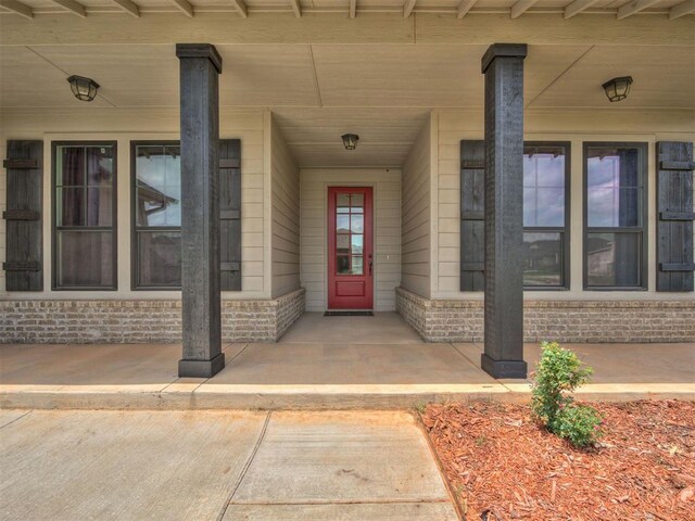 915 Kings Canyon Rd, Norman, OK 73071 - view of exterior entry featuring covered porch and brick siding
