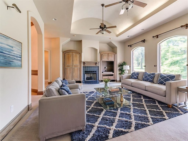 1031 Hidden Valley Ln, Choctaw, OK 73020 - living area with a ceiling fan, recessed lighting, a tray ceiling, a fireplace, and arched walkways