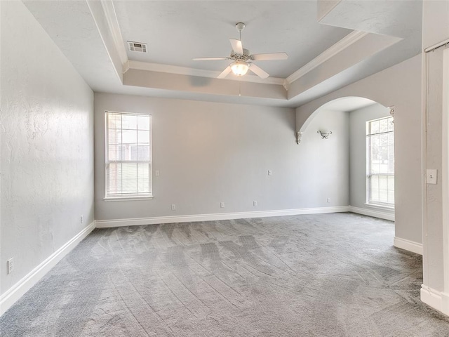 1031 Hidden Valley Ln, Choctaw, OK 73020 - spare room featuring ornamental molding, a tray ceiling, arched walkways, carpet floors, and ceiling fan