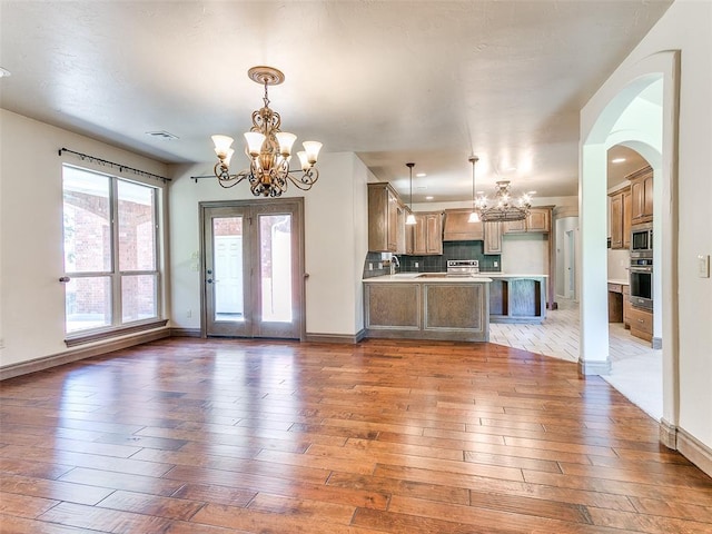 1031 Hidden Valley Ln, Choctaw, OK 73020 - kitchen with a chandelier, appliances with stainless steel finishes, open floor plan, and light wood finished floors