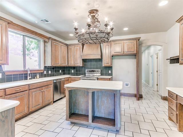 1031 Hidden Valley Ln, Choctaw, OK 73020 - kitchen featuring appliances with stainless steel finishes, custom range hood, arched walkways, light countertops, and decorative backsplash