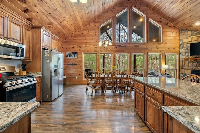 184 Almond Ln, Hochatown, OK 74728 - kitchen featuring appliances with stainless steel finishes, brown cabinetry, wooden walls, wooden ceiling, and dark wood-style floors