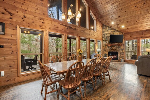 184 Almond Ln, Hochatown, OK 74728 - dining space with wooden walls, a stone fireplace, wood ceiling, wood finished floors, and a chandelier