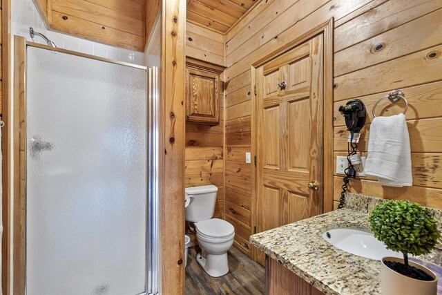 184 Almond Ln, Hochatown, OK 74728 - bathroom featuring wood walls, a shower stall, toilet, vanity, and wood finished floors