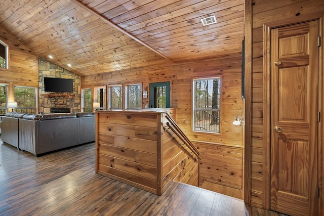 184 Almond Ln, Hochatown, OK 74728 - kitchen featuring a stone fireplace, wood ceiling, dark wood-type flooring, wooden walls, and vaulted ceiling