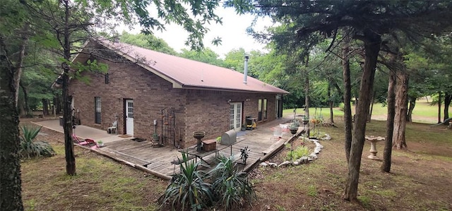 319 W Cedar Ln, Minco, OK 73059 - view of home's exterior with a wooden deck, brick siding, and metal roof