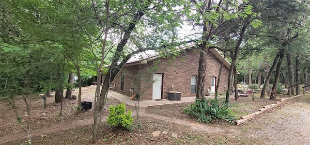 319 W Cedar Ln, Minco, OK 73059 - view of property exterior with brick siding, a patio area, and central AC