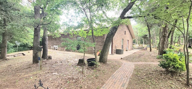 319 W Cedar Ln, Minco, OK 73059 - view of side of property featuring brick siding, a patio, and central AC unit