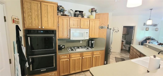 319 W Cedar Ln, Minco, OK 73059 - kitchen with white appliances, a sink, light tile patterned floors, hanging light fixtures, and light countertops