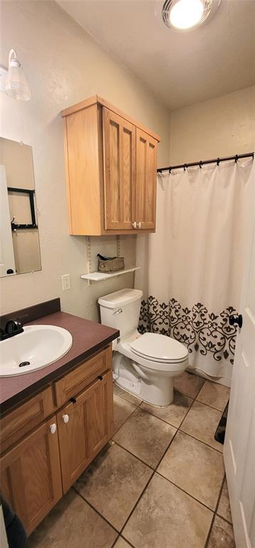 319 W Cedar Ln, Minco, OK 73059 - bathroom with vanity, toilet, tile patterned floors, and a shower with curtain