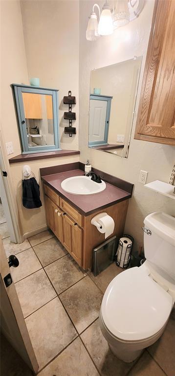 319 W Cedar Ln, Minco, OK 73059 - half bath featuring vanity, tile patterned flooring, and toilet